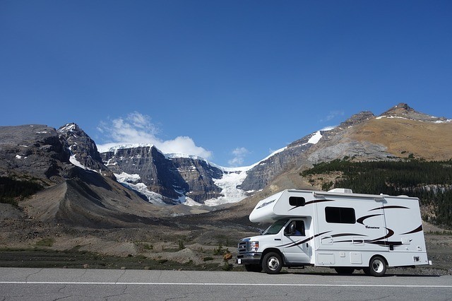 RV driving on road next to mountains