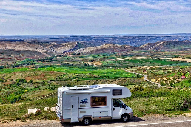 RV parked on the side of the road, overlooking plains